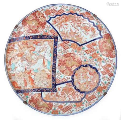 A large Japanese Imari charger, decorated with scholars, dragon and phoenix in various shaped