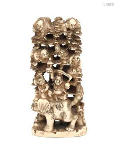 A Japanese ivory 'immortals' okimono with two immortals on a pigs back under a pine tree, the others