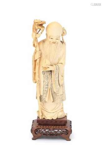 A Chinese ivory sculpture, Shoulao, dressed in long robes, holding a peach and a staff. Circa