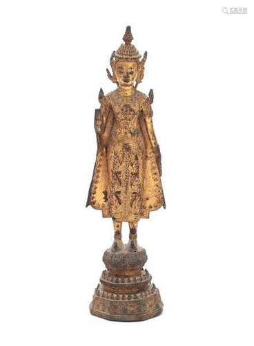 A standing gilt Rattanakosin buddha, in Abhaya mudra, standing on a lotus throne. Thailand, 18/