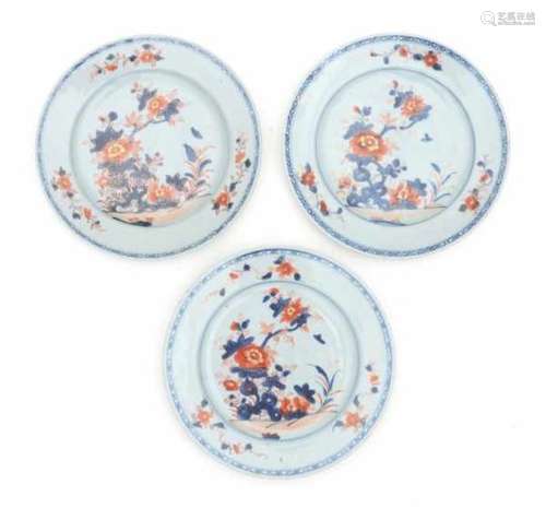 A set of three Chinese Imari plates, decorated with flowers in a rocky garden. 18th