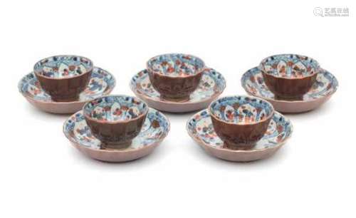 A set of five Chinese 'café au lait' cup and saucers, the inside decorated in Imari style with