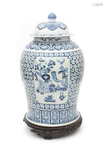 A large Chinese blue and white lidded vase, decorated in four panels with precious objects. On