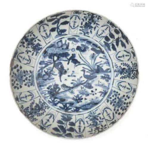 A Chinese blue and white charger, decorated with ducks on the waters edge with lilies. Late Ming