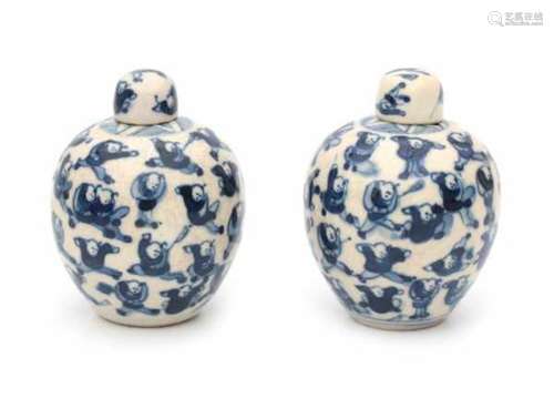 A pair of Chinese blue and white softpaste lidded jarlets, decorated with playing boys. Marked