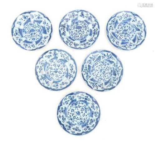 A set of six Chinese blue and white export plates, decorated with flowers in petal shaped panels.