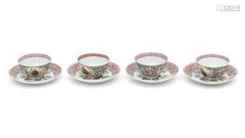 A set of four Chinese famille rose cup and saucers, decorated with precious objects highlighted in