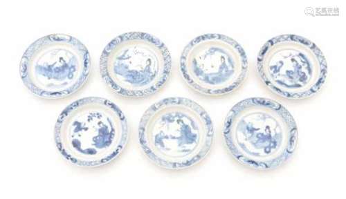 A set of seven Chinese blue and white saucers, decorated with an elegant lady and a playing boy.