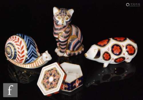 A collection of three Royal Crown Derby paperweights comprising a pig, a cat and a snail together