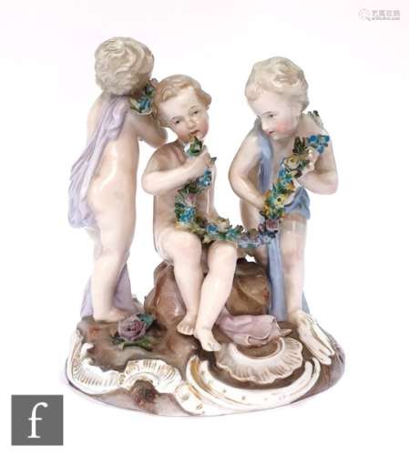 A 19th Century continental figural group of three young boys in loose robes holding floral garlands,