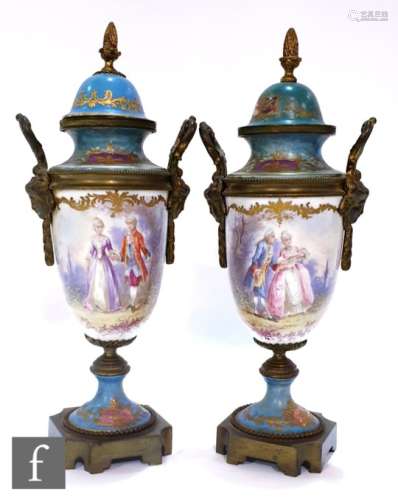 A pair of 19th Century continental Sevres style vases of urn form with covers and gilt metal mounts,