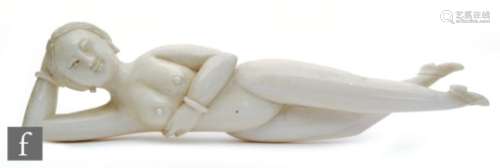 A Chinese late 19th to early 20th Century carved ivory medicine figure, carved as a recumbent nude