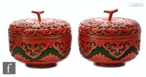 A pair of Chinese red cinnabar lacquer lidded pots, each of rounded peach form, surmounted by a