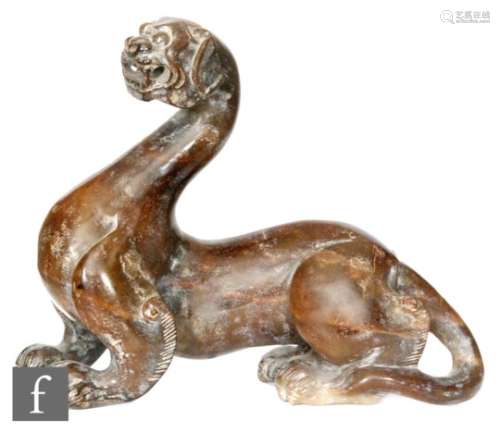 A Chinese green hardstone figure of a chilong, modelled in recumbent position with curled tail,