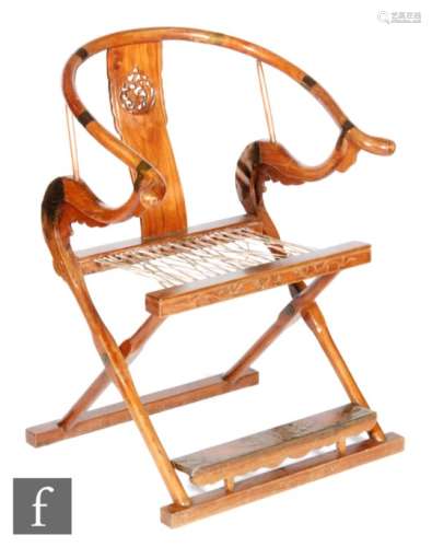 A Chinese 20th Century hardwood horseshoe-back folding chair with a carved openwork splat with