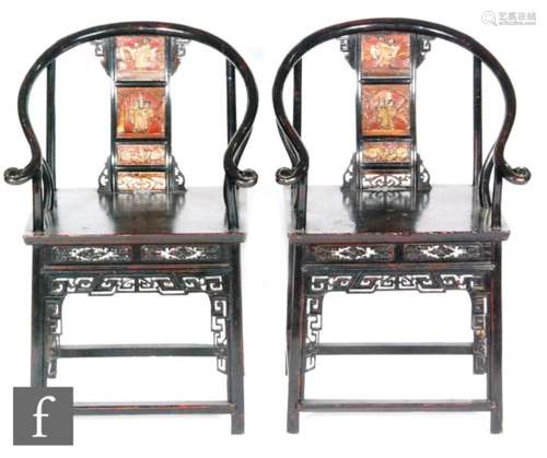 A pair of Chinese ebonised horseshoe shaped elbow chairs, the red and gilt lacquered back splats