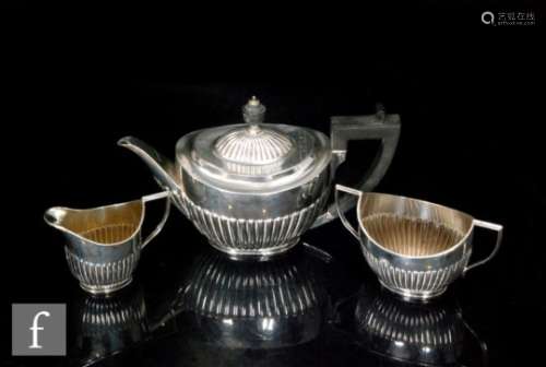 A hallmarked silver three piece bachelor's boat shaped tea set with part fluted decoration, total