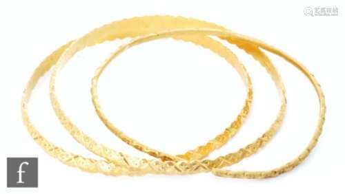 Three 22ct Indian gold bangles to include a torque example, all with engraved decoration, total