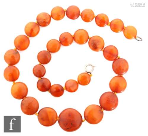 A graduated single row of amber disc shaped beads, length 47cm, weight 28g, largest diameter 2cm.