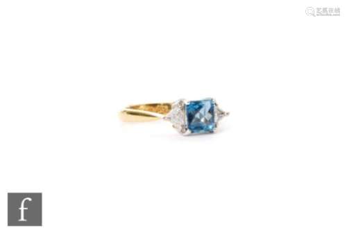 An 18ct hallmarked aquamarine and diamond ring central facet cut square aquamarine flanked by