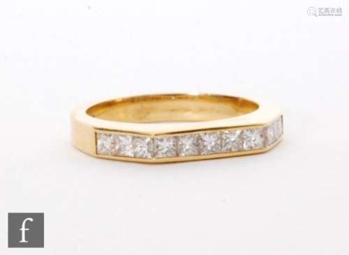 An contemporary platinum hallmarked diamond half eternity ring comprising nine brilliant cut channel