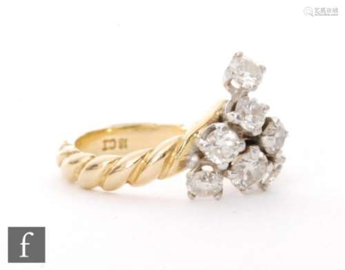 A contemporary 18ct diamond cluster ring, seven brilliant cut stones to a vertical claw setting,