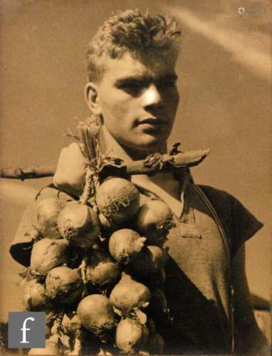 MONTAGUE GLOVER (1898-1983) - Portrait of Ralph carrying a string of onions, monochrome