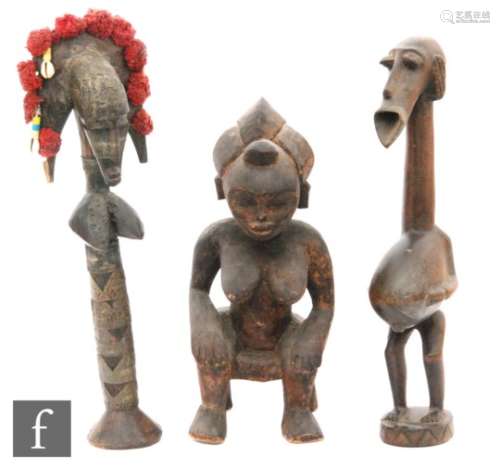 A 20th Century Yoruba carved hardwood fertility figure of a female on a stool, height 34cm, a
