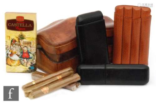 A tooled leather serpentine shaped cigar box, a four divisioned cigar holder and two black leather