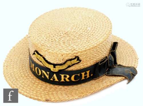 An Eton straw boater hat with ribband titled Monarch and pressed brass badge Floreat Etona by E C