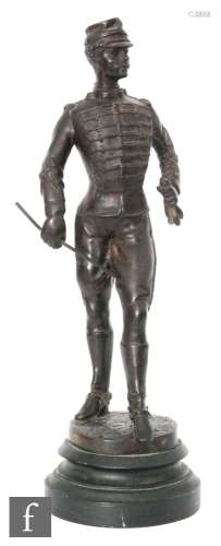 A late 19th Century spelter figure of a young dragoon officer wearing a peaked cap and holding a