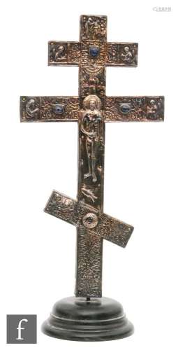 A Russian white metal cross with a figure of Christ, to each side mounted and inset with coloured