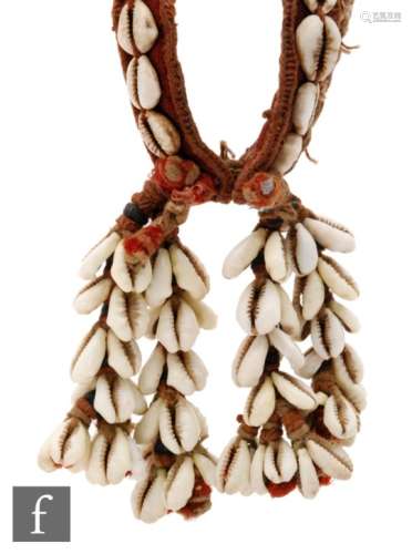 A late 19th and early 20th century African cowrie shell bracelet, four bunches of shells and chord.
