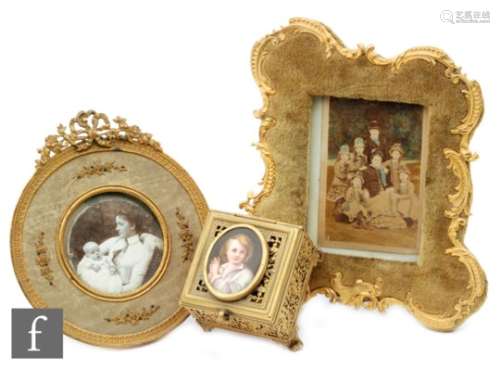 An early 20th Century gilt edge easel photograph frame with bow mount, a similar velvet cartouche