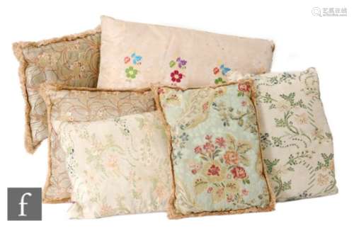 A small pair of 1930s cushions, all over embroidered with a floral design on a pale green ground,