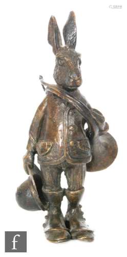 A 20th Century bronze desk stand modeled as Brer Rabbit holding a French horn, suited and holding