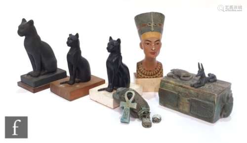 A small museum bust of Nefertiti, three facsimile Egyptian cats, and various souvenir and tourist