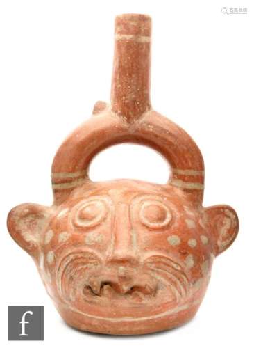 A Peruvian feline effigy stirrup vessel modelled as a stylised cat with sharp teeth and central