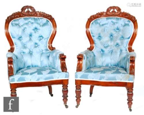A pair of Victorian mahogany framed spoon back library armchairs, with acanthus carved top rails and