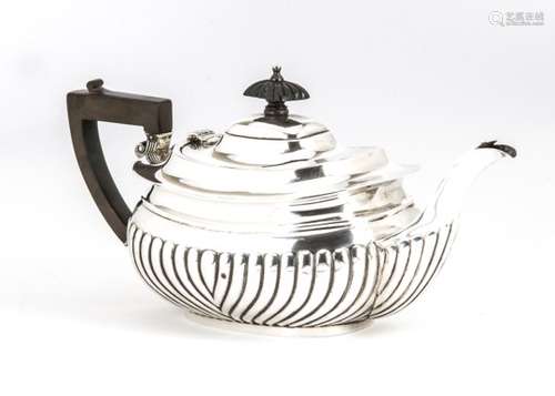 An early George V silver teapot, fluted lower, applied handle and finial, marked Chester 1911,