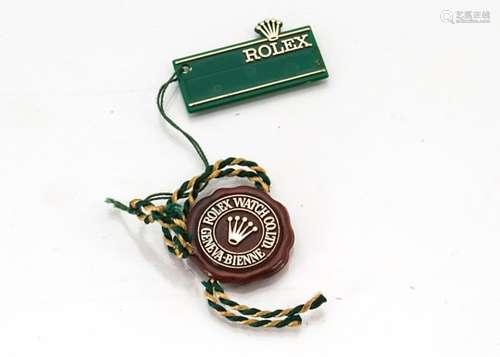 A Rolex maroon and gilt plastic retail tag, with Rolex Datejust green and gilt tag