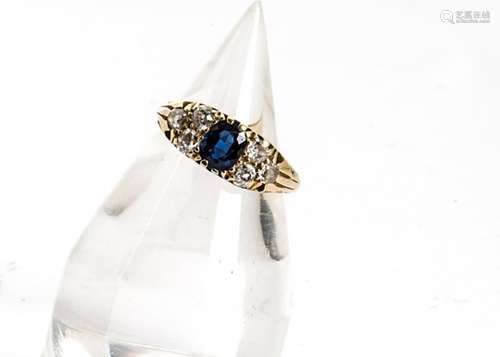 An Edwardian sapphire and diamond gold ring, the oval mixed cut sapphire in claw setting flanked