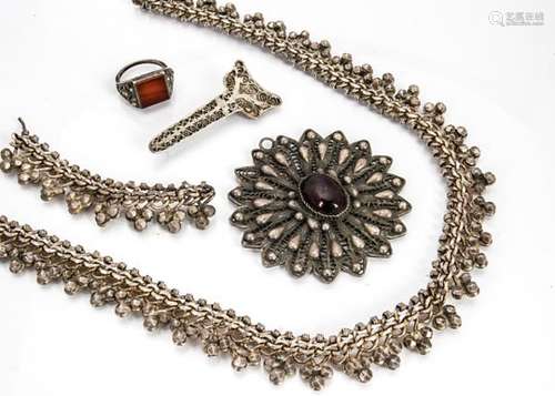 A collection of North African silver jewels, including a fringe necklace, a paste set filigree