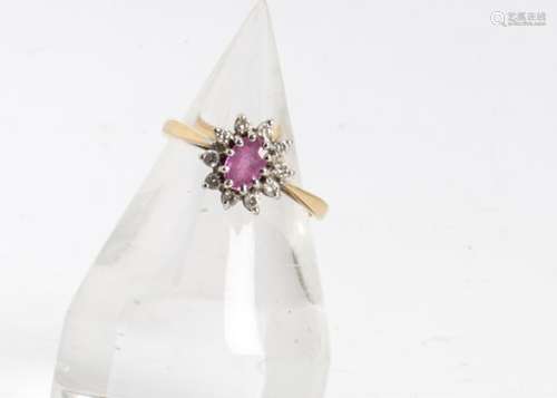 An 18ct gold hallmarked pink sapphire and diamond cluster ring, the oval mixed cut central pink