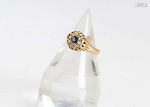 An Edwardian 18ct gold sapphire and diamond cluster ring, the circular Ceylon sapphire surrounded by