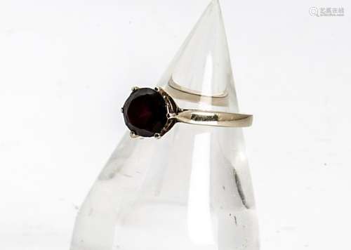 A continental yellow gold and garnet set dress ring, the red garnet claw set circular cut central