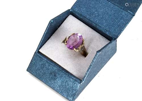 A large amethyst and diamond dress ring, the oval cut amethyst on an ornate claw setting set with