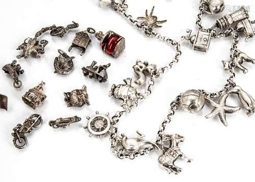 A continental white metal necklace, set with various charms including ewers, keys, lighthouse,