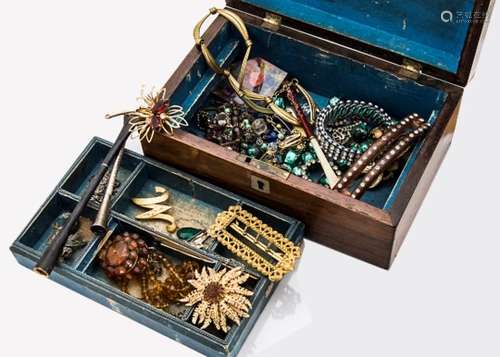 A collection of costume jewellery, including an amber target brooch, a glass amber necklace, gilt