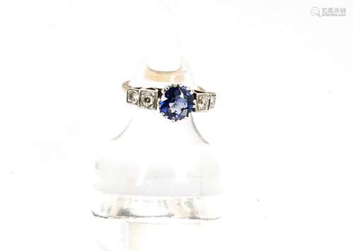 An Art Deco sapphire and diamond dress ring, the circular cut central claw set sapphire flanked by